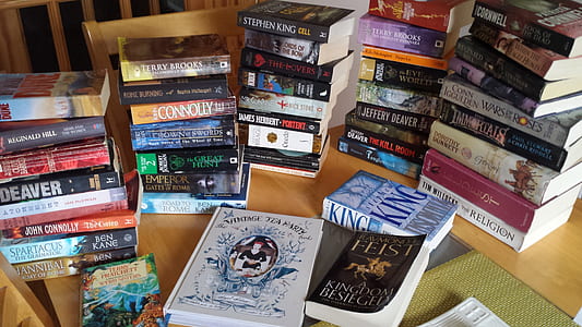 assorted-title novel books on brown wooden table thumbnail