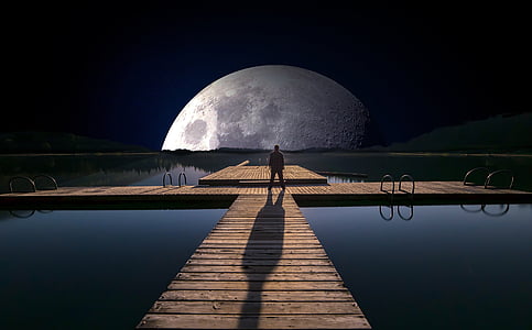 man standing on wooden dock at night thumbnail