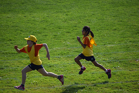 two girls running on green grass field at daytime thumbnail