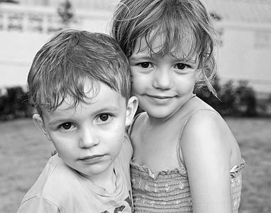 grayscale photo of two children shallow focus photography thumbnail
