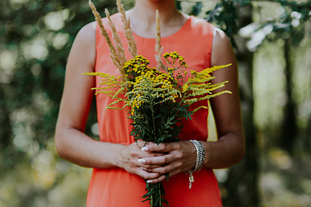 Woman in a red dress with flowers outdoors thumbnail