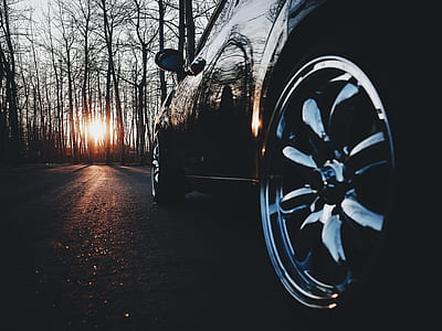 black vehicle on road near trees during sunset thumbnail