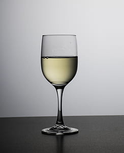 clear wine glass filled with beige liquid thumbnail