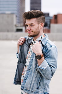 selective focus photo of man holding his blue-washed denim jacket thumbnail