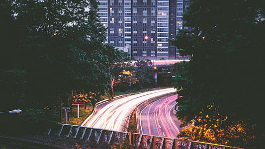 time lapse photography of road between trees thumbnail