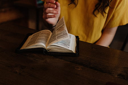 selective focus photography of woman flipping book page thumbnail