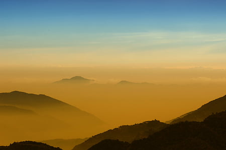 rock mountain covered with fog during daytime thumbnail