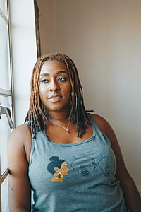 woman wearing gray tank top look at window thumbnail