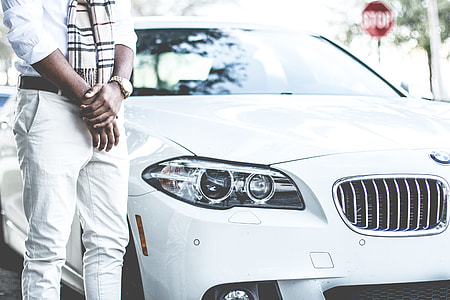 man standing beside white BMW car thumbnail