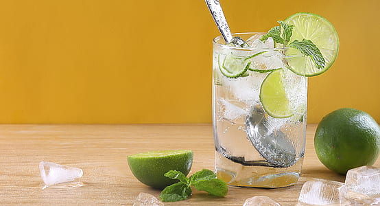 sliced lime near the clear drinking glass on brown surface thumbnail