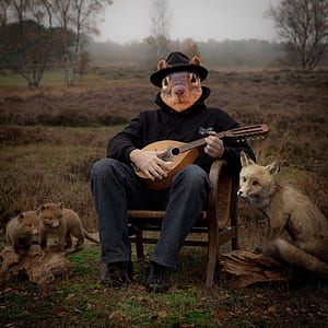 man playing guitar outdoor with three red foces thumbnail