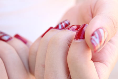 person taking photo of red manicure thumbnail