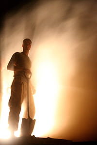 man wearing gray shirt and pants holding shovel thumbnail