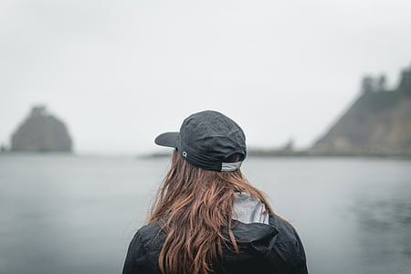 person facing body of water with rock isles thumbnail