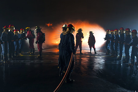 fireman holding water hose infront of fire thumbnail