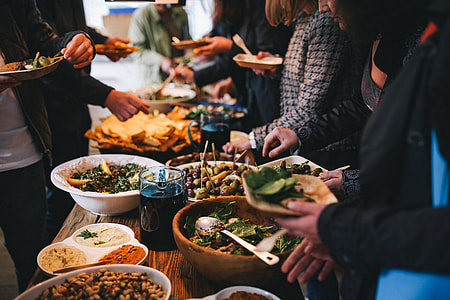 People by a banquet table full with food thumbnail