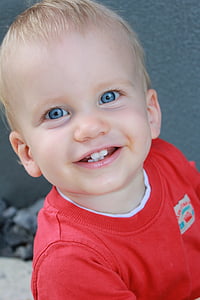 boy smiling while wearing red crew-neck t-shirt thumbnail