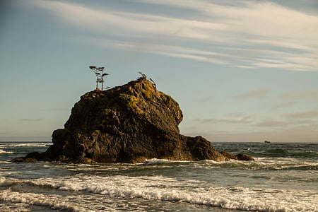 brown rock formation on body of water thumbnail