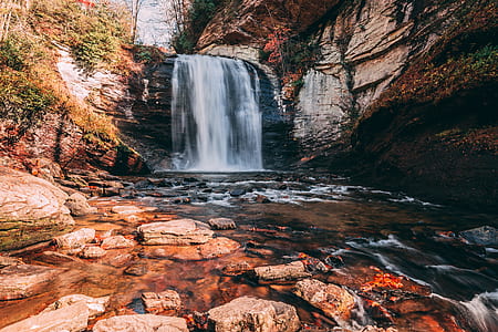 waterfalls surrounded by green trees during daytime thumbnail