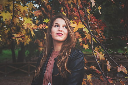 woman looking upper left near autumn leaf tree thumbnail