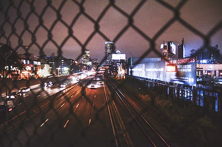 time lapse photography of road with running cars surrounded by buildings thumbnail
