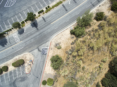 aerial photography of gray road near green grass and trees during daytime thumbnail