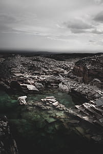 body of water surrounded with rock slabs thumbnail