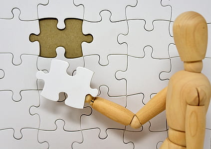 closeup photo of brown wooden dummy holding white puzzle piece thumbnail