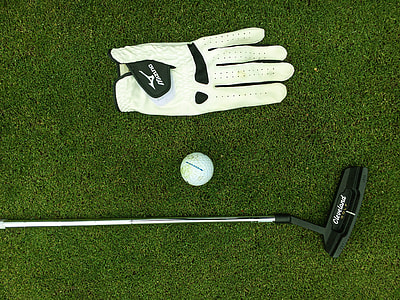 close up photo of black golf putter, white golf ball and unpaired white glove thumbnail