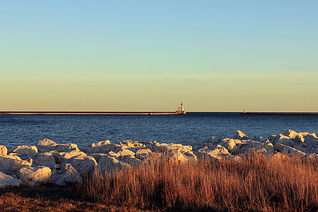 lighthouse near boat during golden hour thumbnail