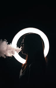 woman smoking against dark background thumbnail