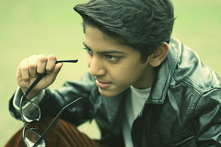 sitting man wearing black leather jacket holding black eyeglasses thumbnail