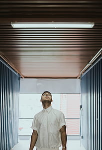 man standing on pathway while looking in fluorescent lamp thumbnail