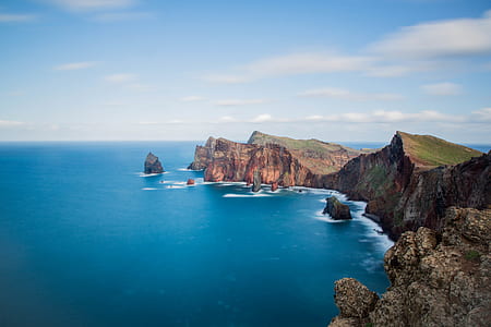 aerial photography of cliff surrounded by body of water thumbnail