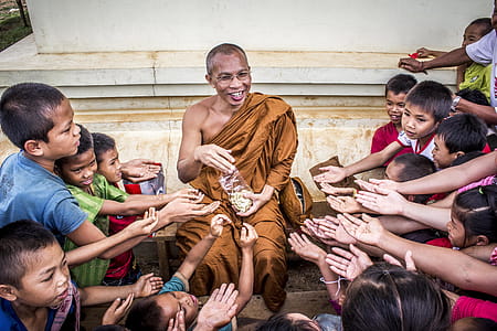 Man in Monk Dress Between Group of Children thumbnail