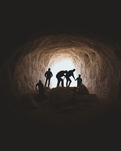 silhouette of people inside cave near open area at daytime thumbnail