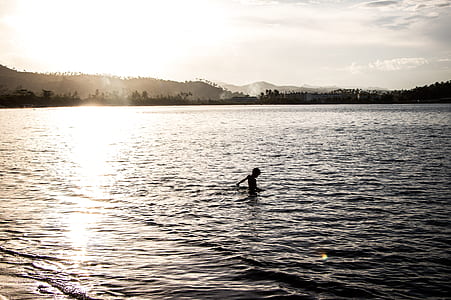 silhouette photo of boy at sea thumbnail