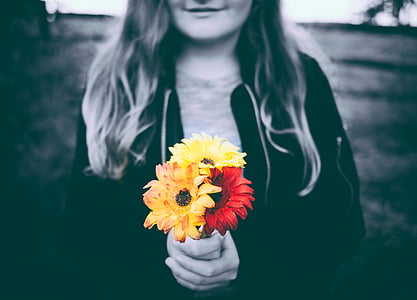 selective photo of girl holding flowers thumbnail