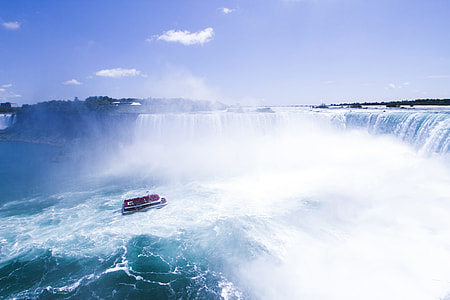 boat in front of waterfalls during daytime thumbnail