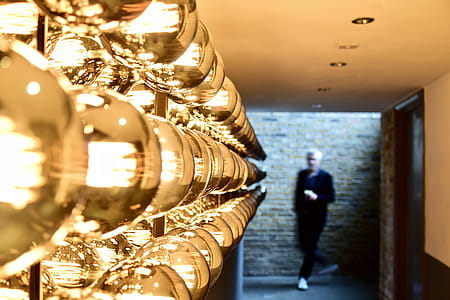 Man Passing Near Brown Brick Wall thumbnail