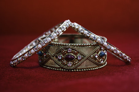 silver and gold studded bangles  on red textile thumbnail