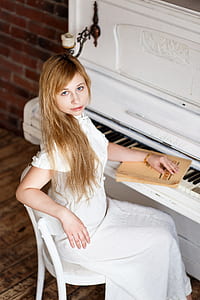 woman sitting in front of upright piano thumbnail