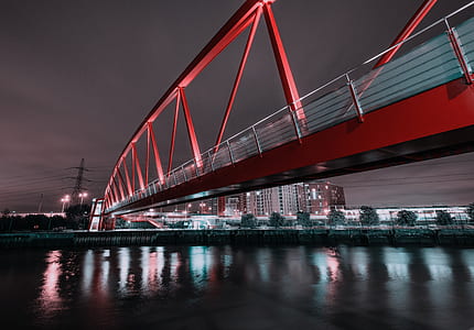 red metal bridge above calm body of water at night thumbnail