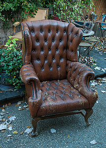 brown leather armchair on black asphalt road thumbnail