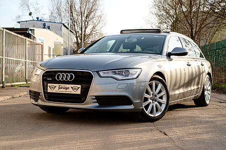gray Audi A-series hatchback on gray road near fence during daytime thumbnail