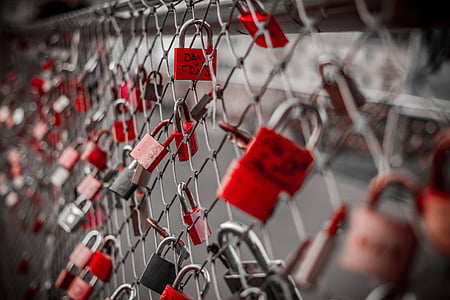 red padlocks on gray cyclone fence thumbnail
