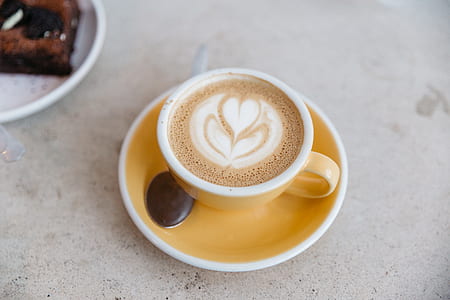 cup of latte with coffee art on top of saucer thumbnail