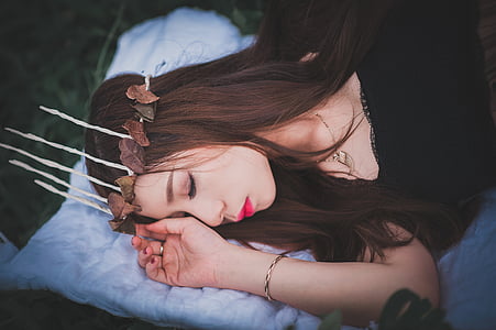 woman in black top sleeping while wearing brown lei thumbnail