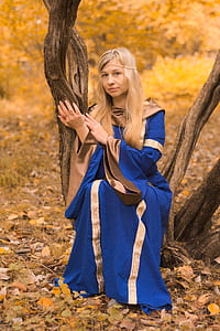 woman in blue and brown dress sitting on tree thumbnail