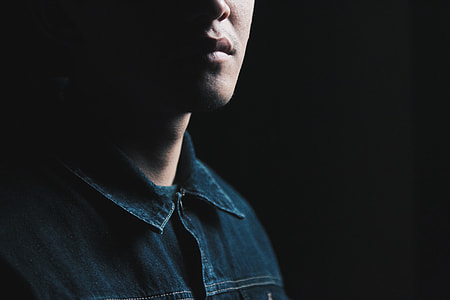 man wearing black button-up shirt inside dark room thumbnail
